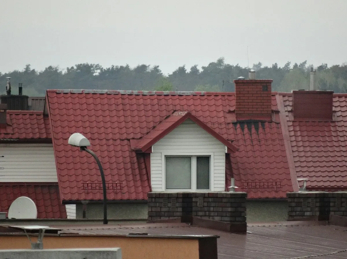 Roof Repair in Lawndale — brick chimneys and a dormer on a red tile roof