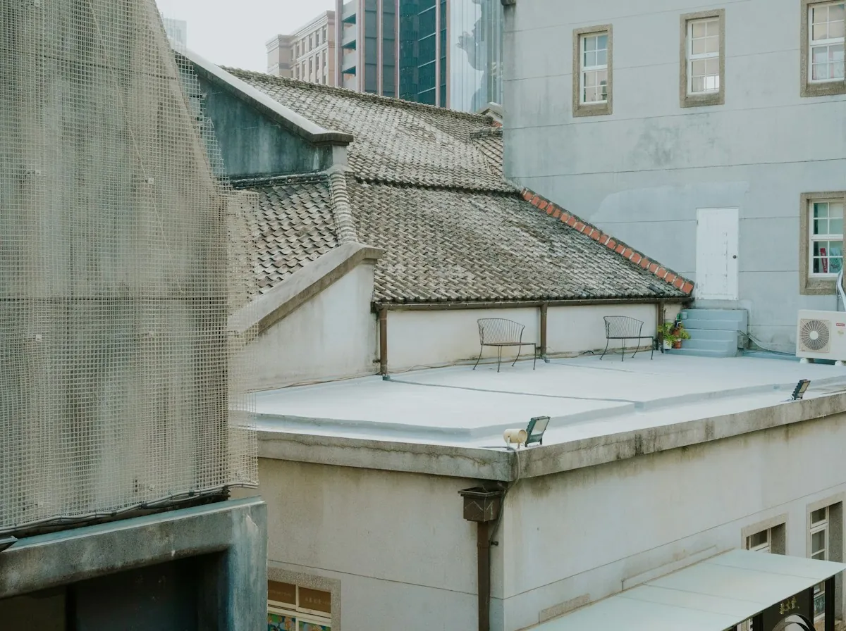 Flat Roof Repair in Lawndale — a flat roof with a gravel surface between taller buildings
